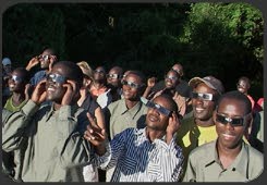 The staff of Sausage Tree Camp view the sun with eclipse-viewing glasses.