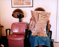 Woman under dryer hood